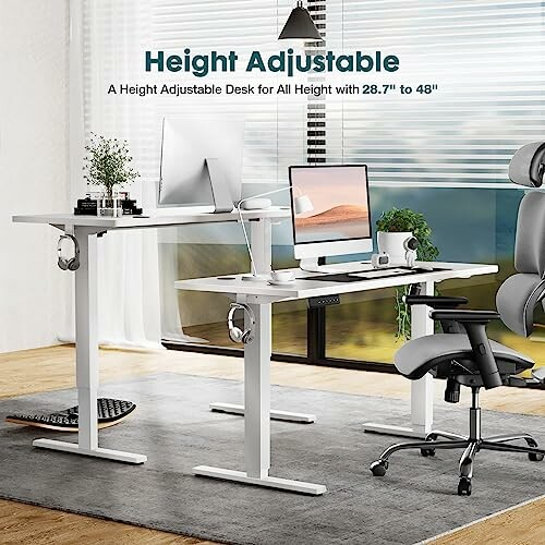 Height adjustable desk setup with computers and office chair.