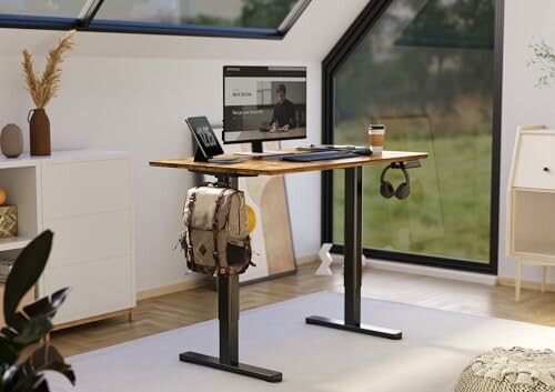 A modern home office with a standing desk, computer, and decor.