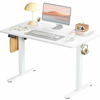 Modern white desk with computer, lamp, and accessories.